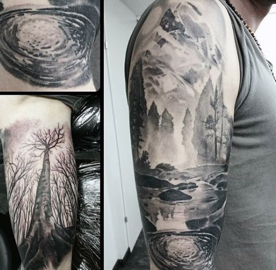 Black and grey sleeve tattoo with a mountain lake, forest trees, and rippling water, paired with a surreal upward tree perspective.