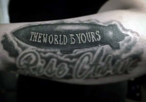 Shaded The World Is Yours Negative Space Blimp Tattoo On Outer Forearm For Men