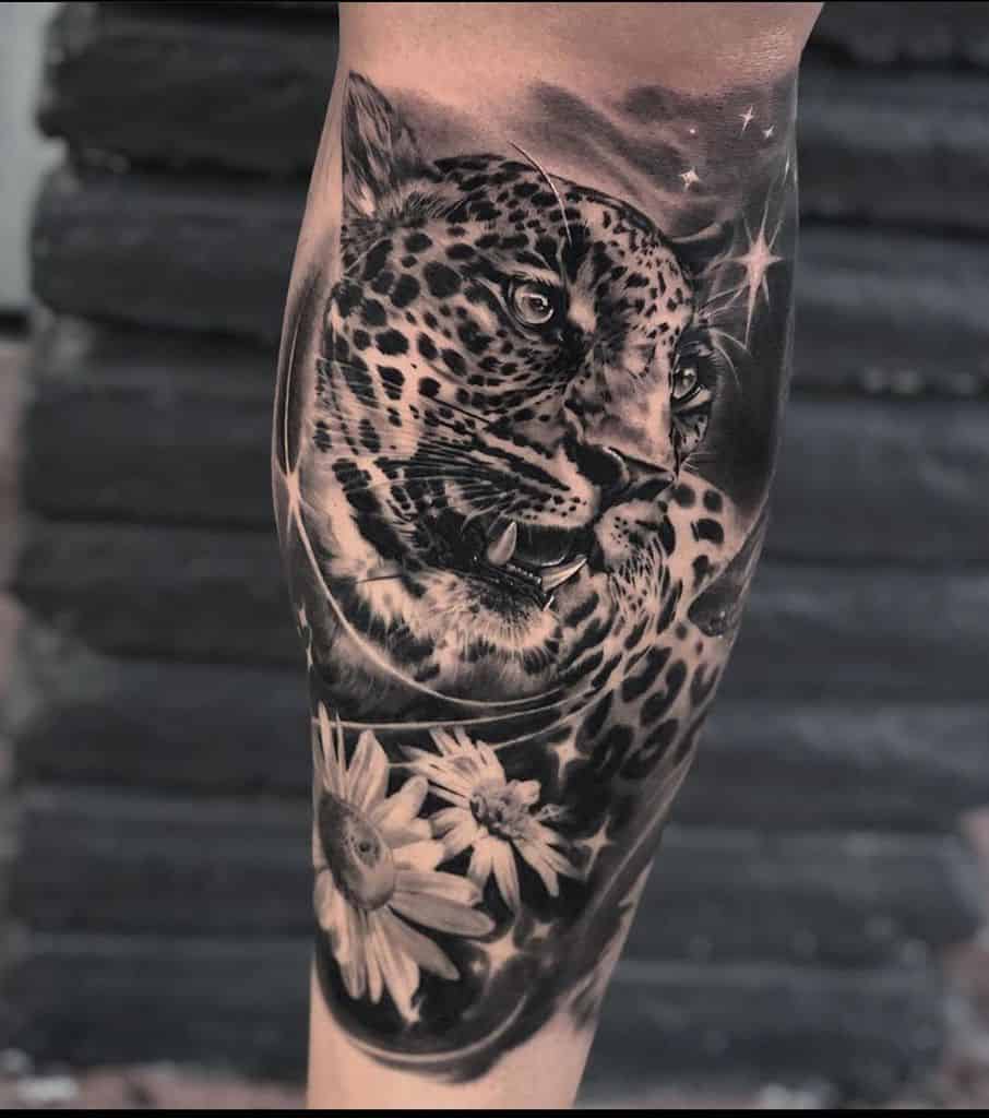 Calf tattoo realistic black and grey shading jaguar with daisies