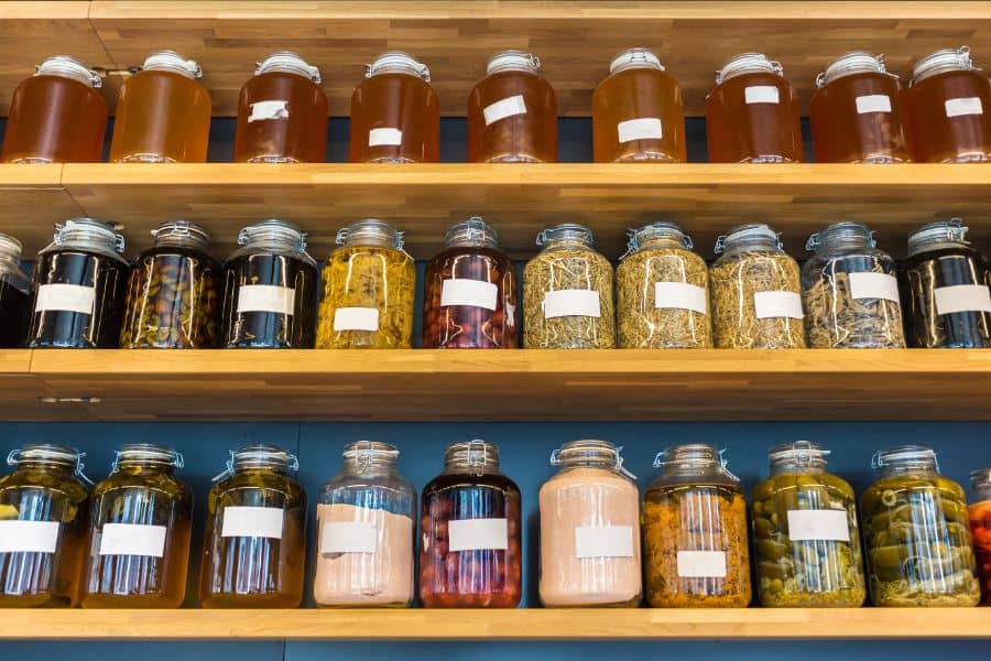 well organized jars on shallow pantry shelving 