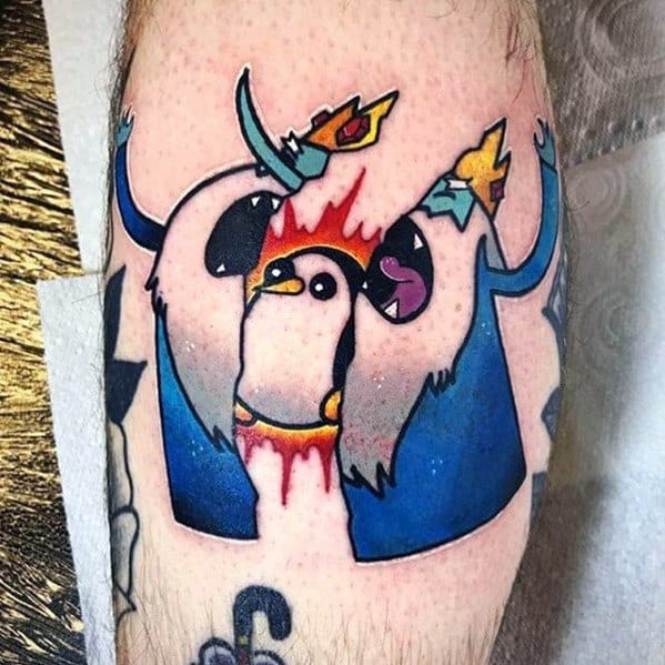 Adventure Time tattoo of Gunter the penguin dramatically splitting the Ice King's body in half with vibrant colors and dynamic action, inked on the leg.
