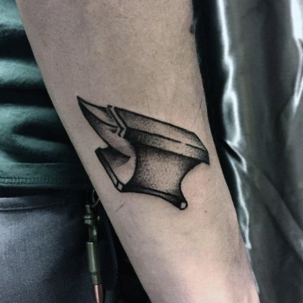 Dotwork anvil tattoo on the forearm with sharp lines and textured shading, creating a bold yet minimalist design.