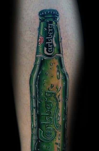 Hyper-realistic tattoo of a Carlsberg beer bottle with detailed condensation and vibrant green tones, creating a lifelike and refreshing appearance on the skin.
