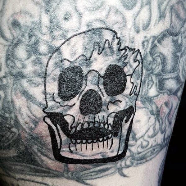 Blast over tattoo of a skull with large black eyes on an intricately inked background