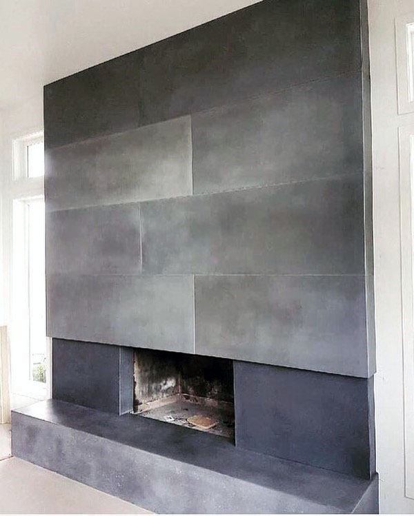 Modern sharp-edged concrete fireplace with a sleek paneled design, offering a minimalist and contemporary aesthetic.