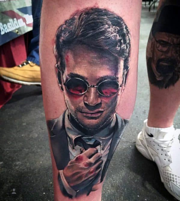 Realistic tattoo of Matt Murdock adjusting his tie with red-tinted glasses, soft lighting, and detailed facial features.