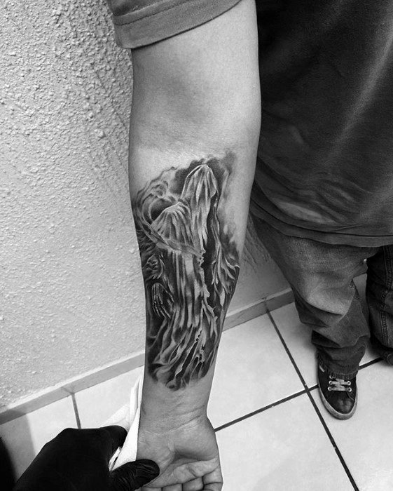 Realistic black and grey forearm tattoo of a Dementor with flowing cloak details and eerie shadowing for a haunting effect.