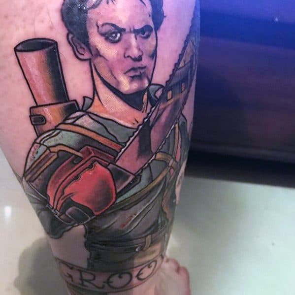 Colorful Evil Dead tattoo of Ash with a chainsaw hand and shotgun on his back, featuring bold outlines and the word “Groovy” below