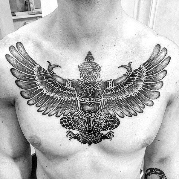 Garuda tattoo on the chest with detailed wings spread wide, showcasing a powerful symmetrical design in bold black ink.