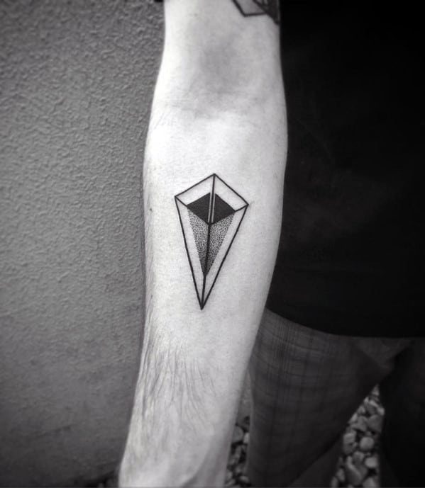 Minimal geometric tattoo on the forearm featuring a sharp, 3D diamond-like shape with clean lines and shaded dotwork.