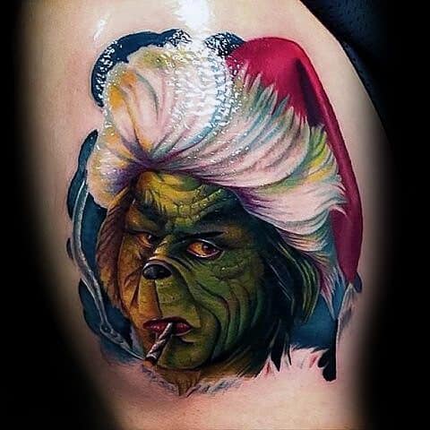 Grinch in a red Santa hat with a mischievous expression and a cigarette in his mouth, surrounded by vibrant colors and detailed shading for a bold and playful tattoo design.