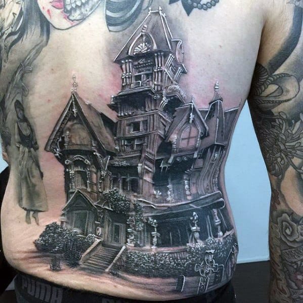 Realistic haunted house tattoo on the side of the torso, featuring a detailed gothic mansion, dark shadows, and a ghostly figure floating nearby.