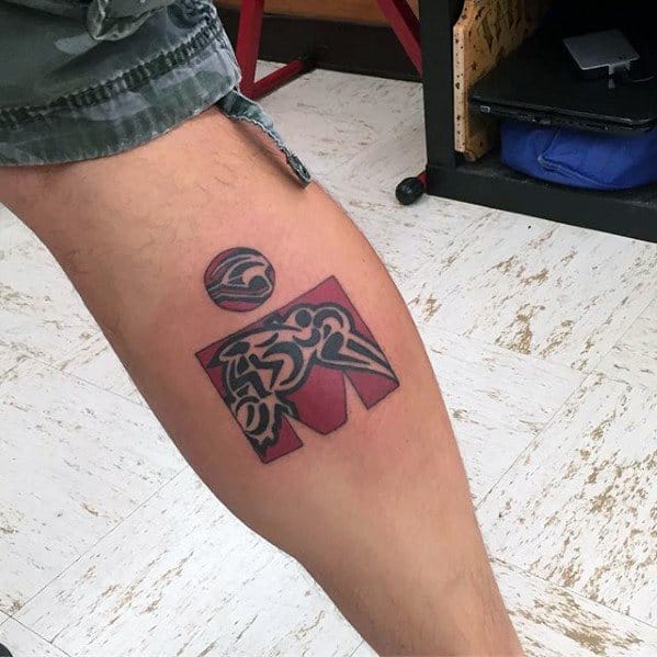Tattoo combining the Ironman logo with abstract tribal elements, highlighting strength and endurance, complemented by a circular shape above the logo.