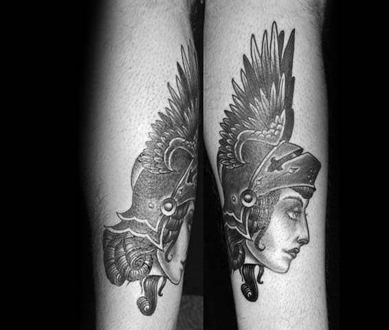 Black and grey Joan of Arc tattoo with a dramatic winged helmet, detailed shading, and a strong side profile symbolizing warrior spirit.