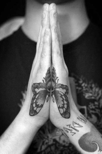 Matching side hand tattoos forming a symmetrical butterfly when hands are pressed together, detailed in bold black ink.