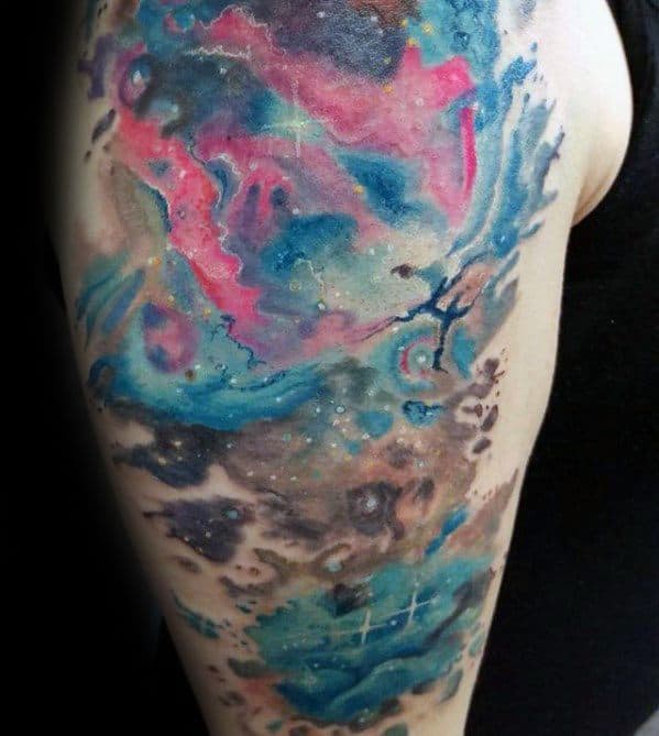 Vivid nebula tattoo with swirls of blue, pink, and purple on an arm