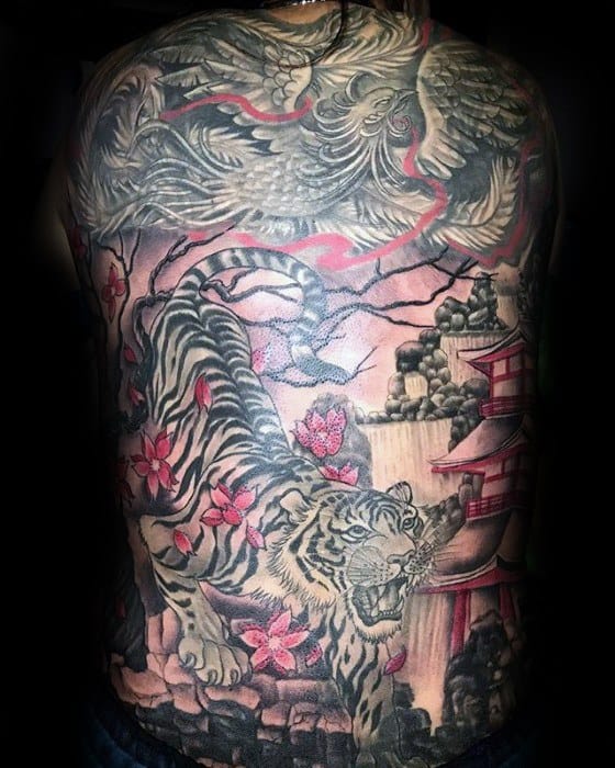 Full back tattoo featuring a fierce tiger with pink cherry blossoms, a red Japanese pagoda, rocky cliffs, and a large koi fish above in black and red tones.