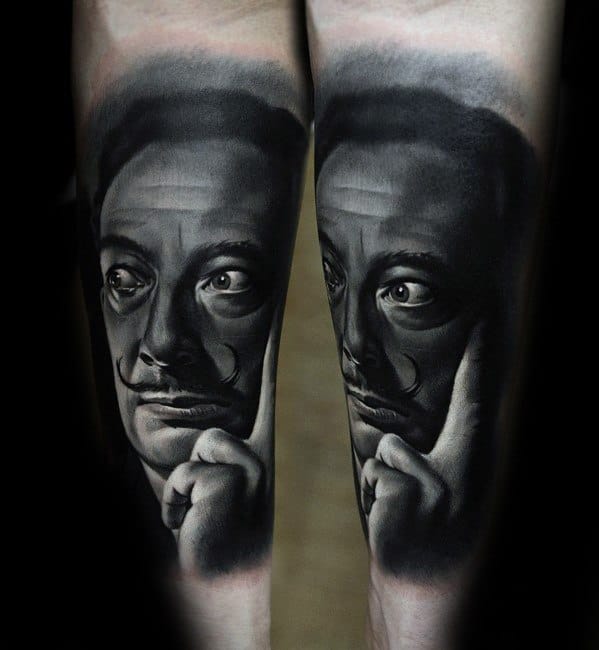 Hyper-realistic black and grey tattoo of Salvador Dali with a contemplative pose, detailed shadows, and expressive highlights for dramatic depth.