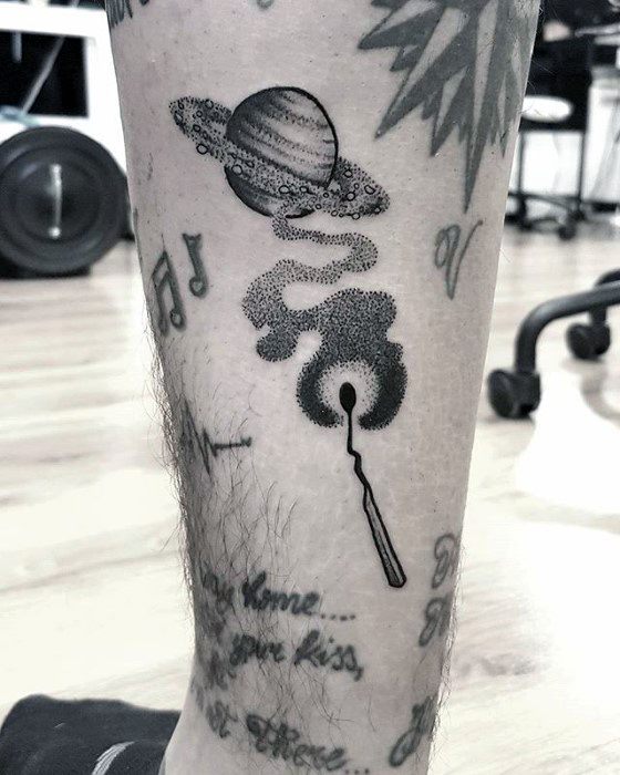 Creative Saturn tattoo design for men showing a matchstick igniting a smoky cosmic trail that forms the ringed planet in dotwork style.