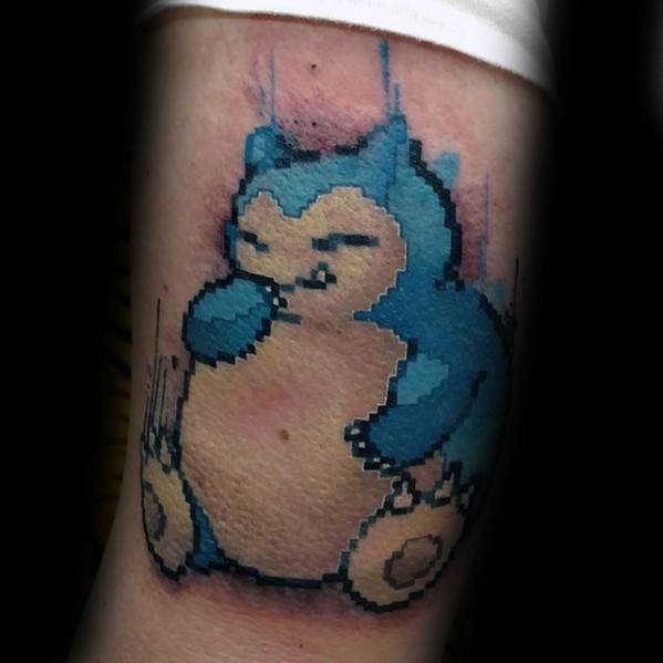 Snorlax tattoo in retro pixel art style with glitch effect, featuring blue and beige tones on the upper arm.