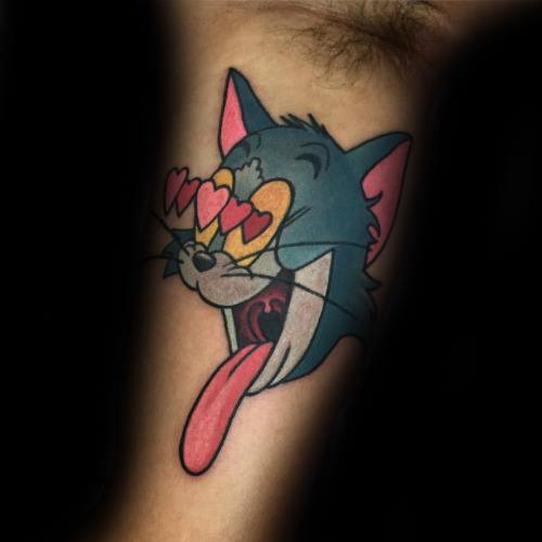 Colorful tattoo of Tom with heart eyes and tongue out, showing a love-struck expression in classic cartoon style.