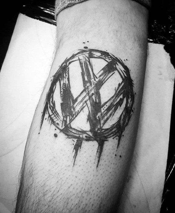 Edgy Volkswagen logo tattoo with a rough, sketch-style design and brushstroke effects, inked in black on the leg.