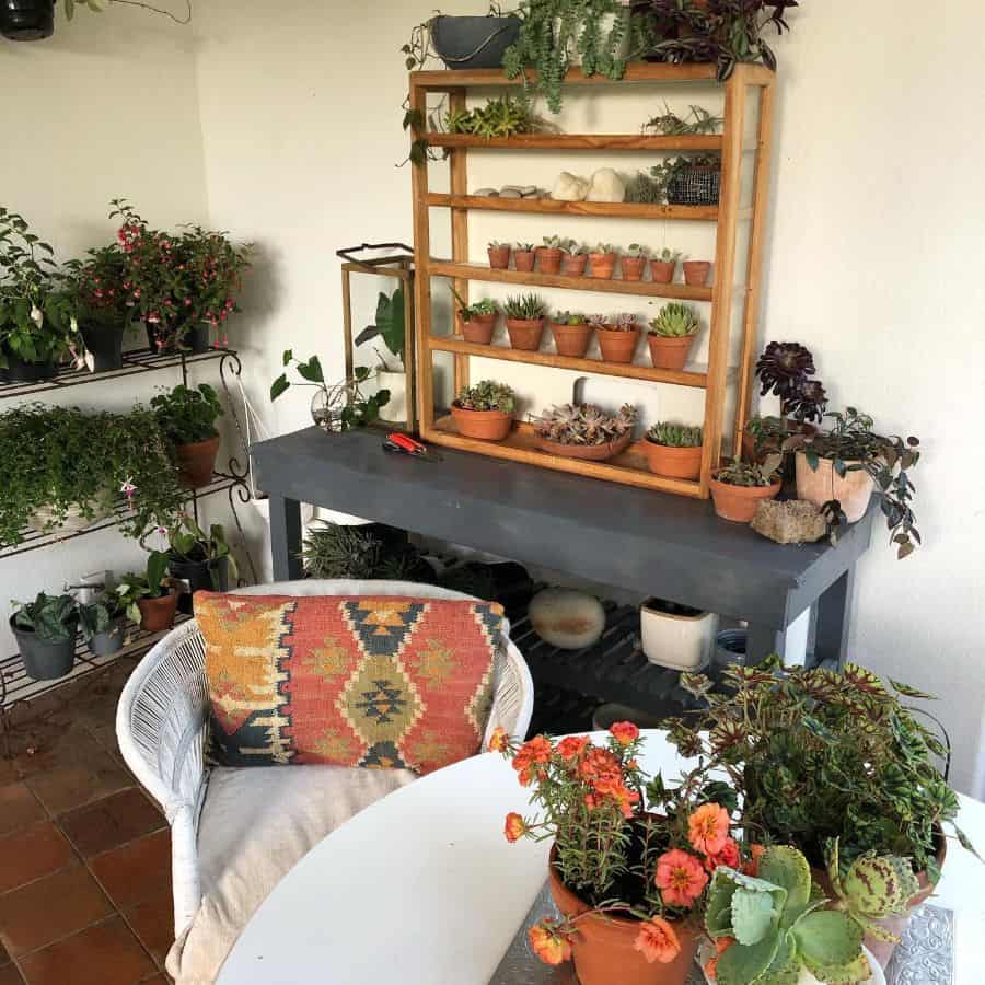 small balcony with pot plants and white wicker chair