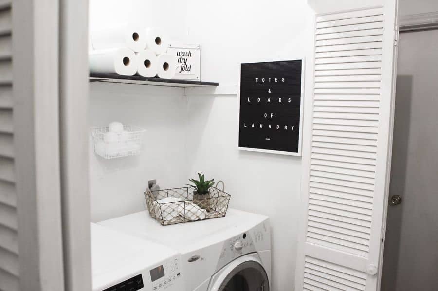 simple white color laundry with glass wall shelf and bi-fold doors