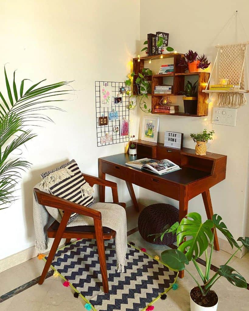 Warm, cozy workspace with wooden desk, wall shelves, plants, and decorative accents.
