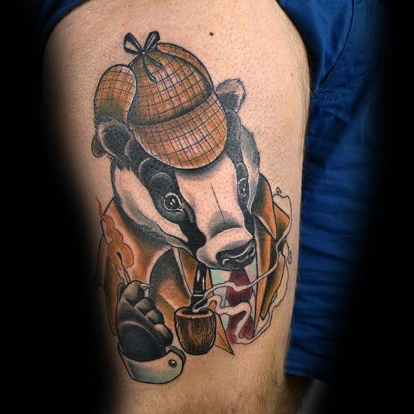 Tattoo of a Sherlock Holmes badger with deerstalker, pipe, and cloak on a person's arm