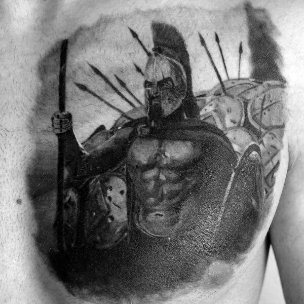Realistic chest tattoo of a Spartan warrior leading a formation, holding a spear and shield, with warriors and spears behind him in battle stance.