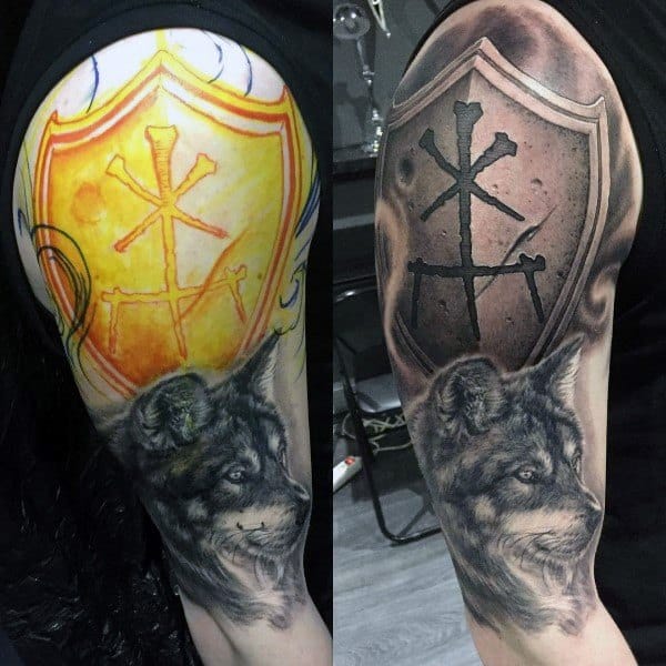 Before-and-after tattoo showing a transformation from a faded yellow shield with symbols to a detailed black and grey design with a fierce wolf.