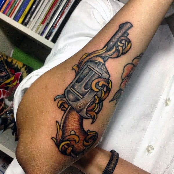 Shiny Pistol With Yellow Patterns Tattoo On Forearms For Men