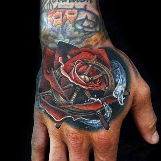 Hand tattoo of a compass and red rose with water splashes