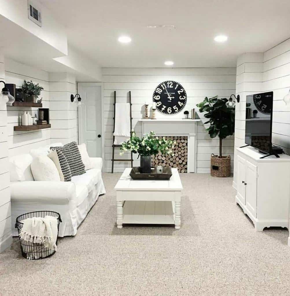 Rustic white living room with shiplap walls, farmhouse decor, and large clock above the mantel.