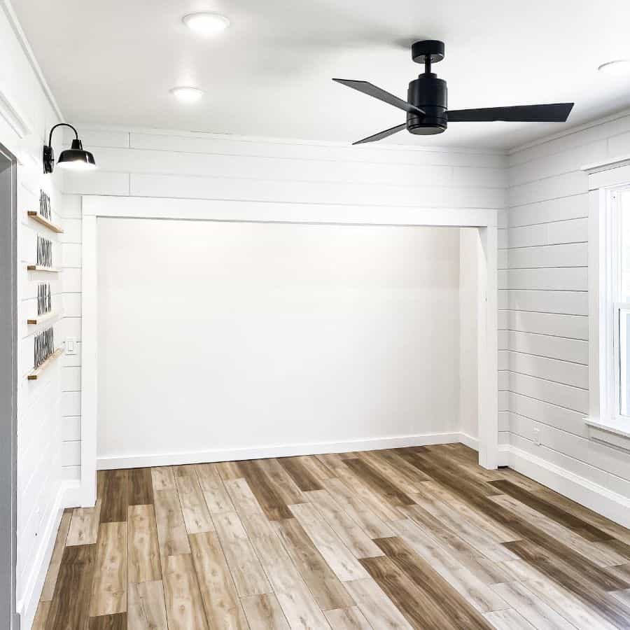 sparse white shiplap spare room wood flooring