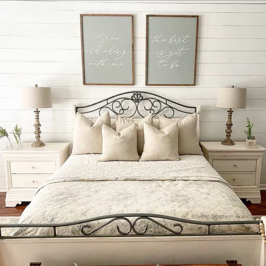Cozy bedroom with a white iron bed, crisp bedding, matching nightstands, and inspirational wall art above