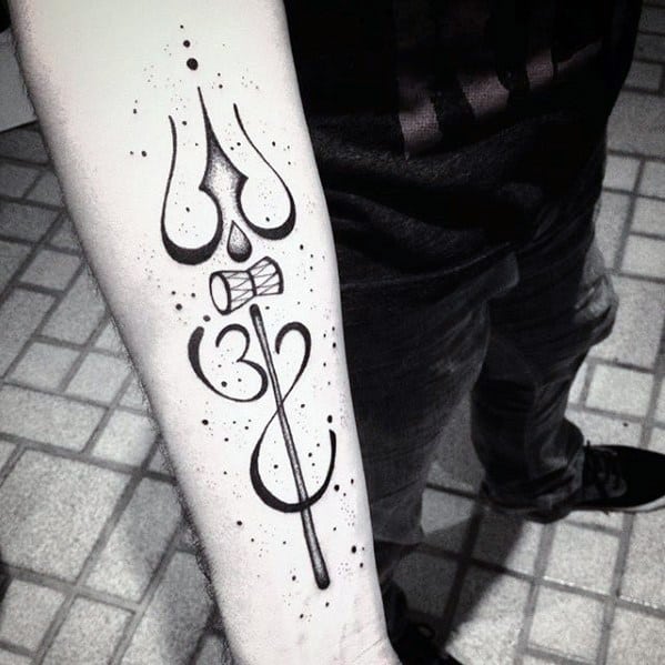 Minimalist forearm tattoo of Lord Shiva’s trishul, damru, and Om symbol, designed with clean black lines and dotted accents for a modern spiritual look.