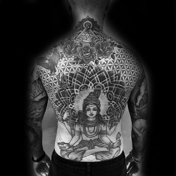 Intricate full-back tattoo of Lord Shiva meditating within a sacred geometric mandala, featuring floral patterns, trident, and detailed cosmic symbolism.