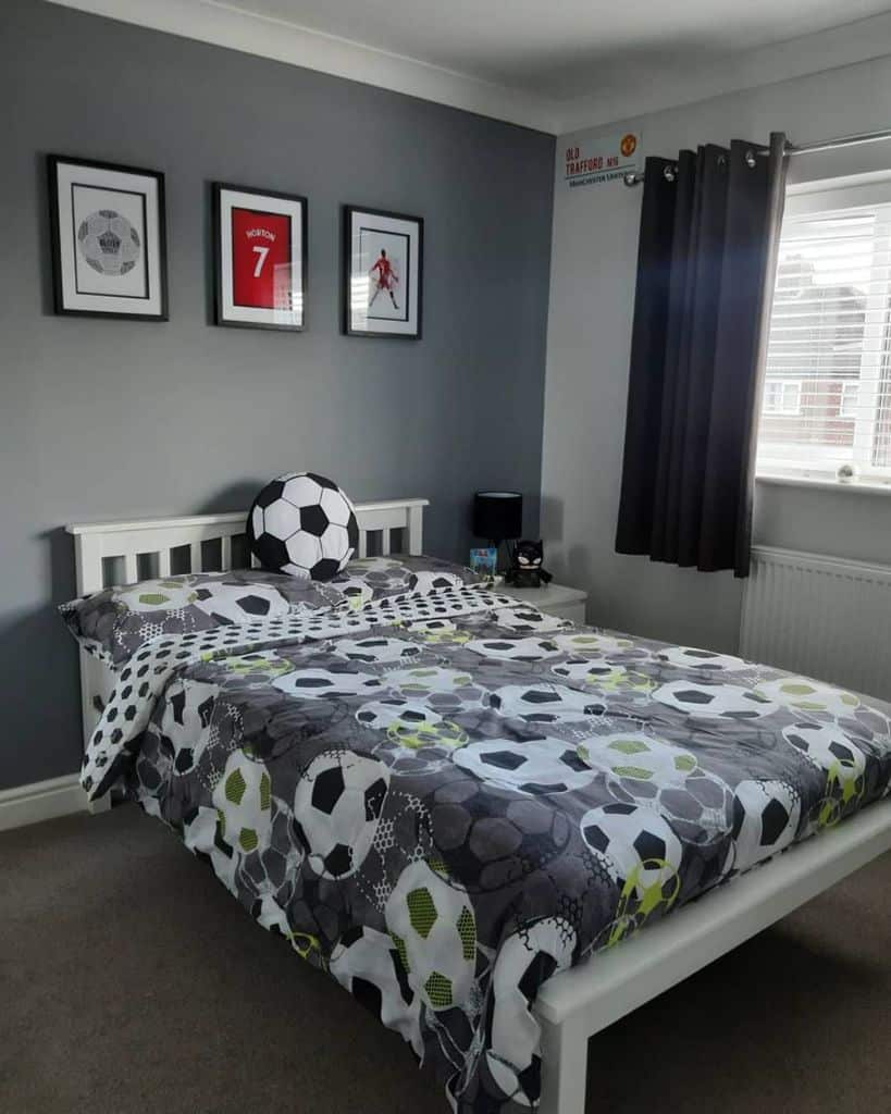 Soccer-themed kids bedroom with soccer ball bedding, wall art, and gray accent wall.