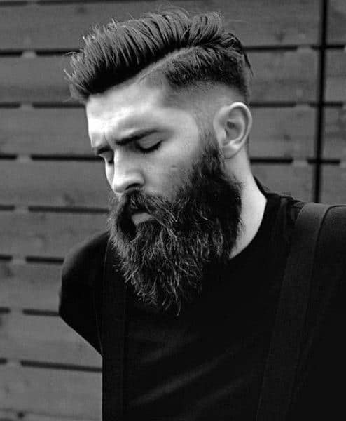 Man with a high fade and voluminous top paired with a full beard