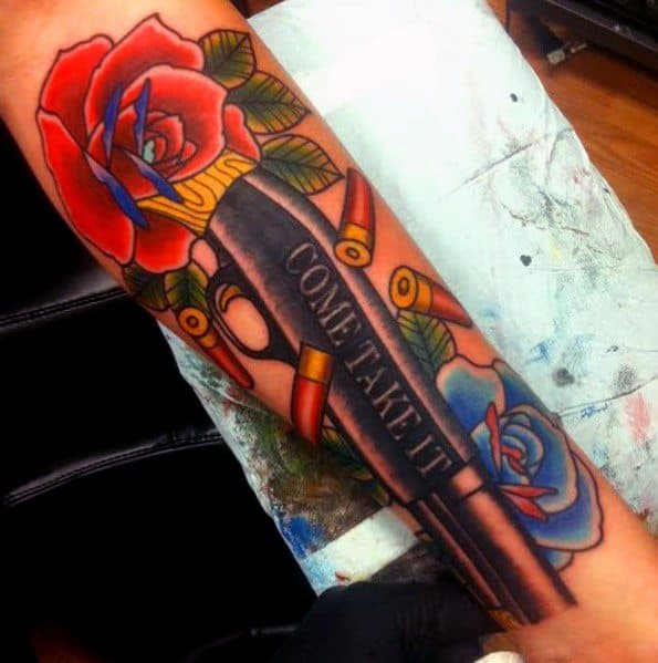 Colorful shotgun tattoo with "COME TAKE IT" engraved on the barrel, surrounded by red and blue roses and scattered shotgun shells for a bold design.