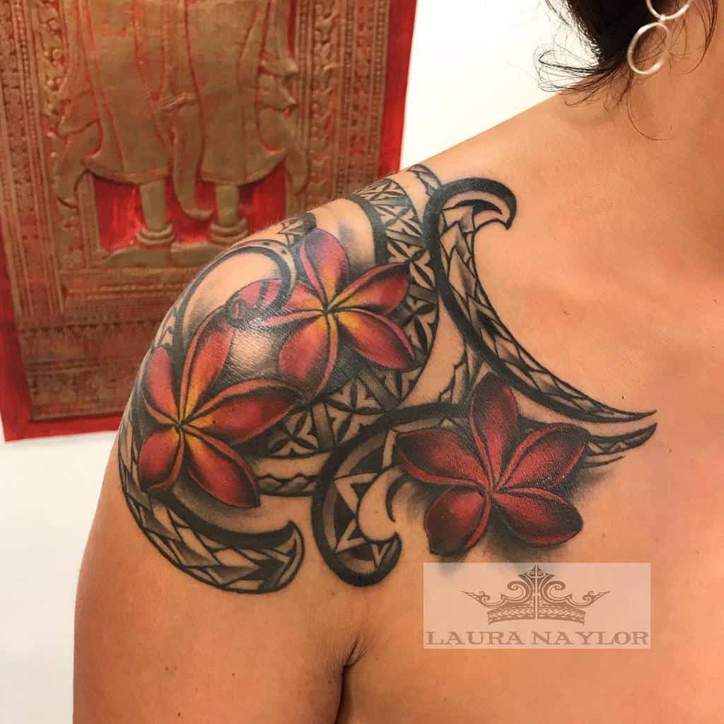 Intricate shoulder tattoo featuring red plumeria flowers and black tribal designs