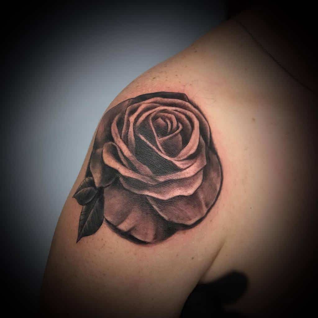 Black and gray rose tattoo on a shoulder