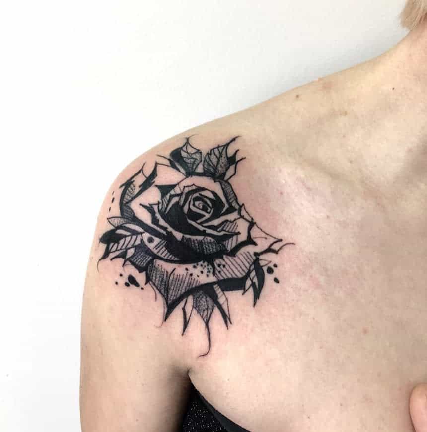 A stunning black rose tattoo gracefully adorns a person's shoulder, capturing its elegant allure with intricate detail