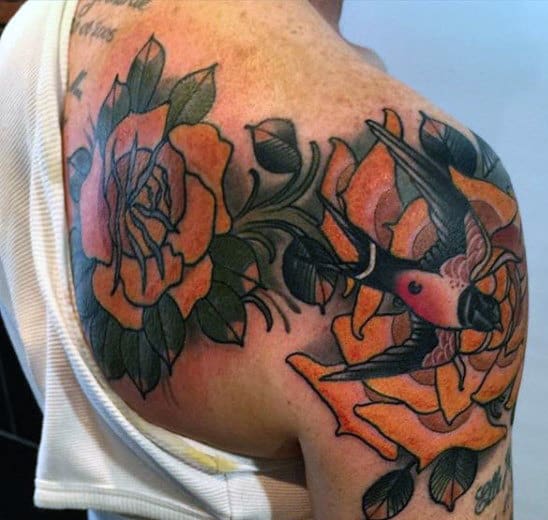 Colorful bird and roses tattoo on a shoulder and upper arm