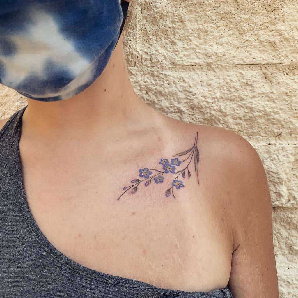 Woman with a forget-me-not floral tattoo on her shoulder