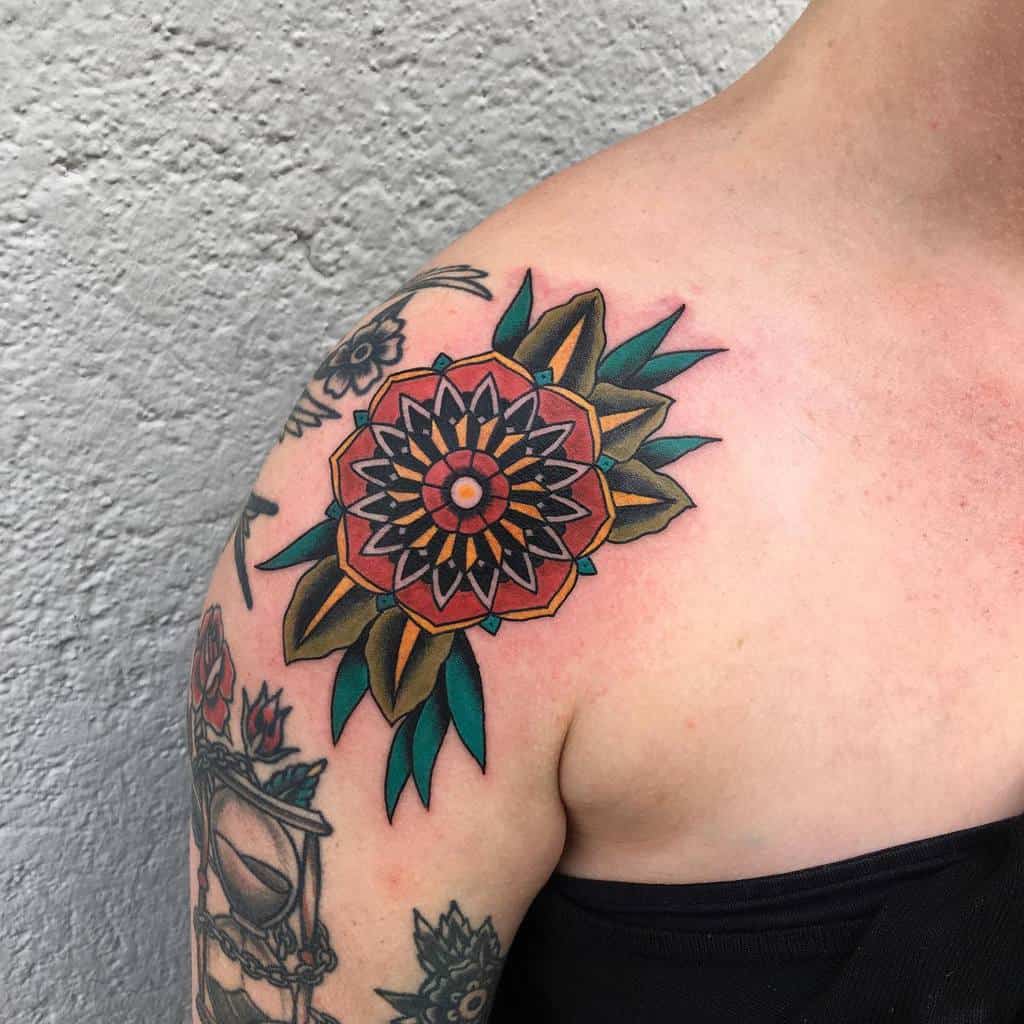 Colorful geometric flower tattoo with leaves on an upper arm and shoulder