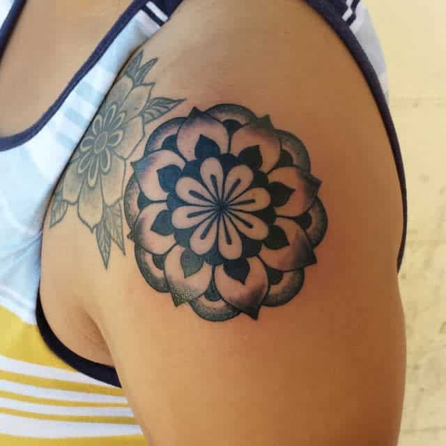 A floral mandala tattoo on an upper arm 
