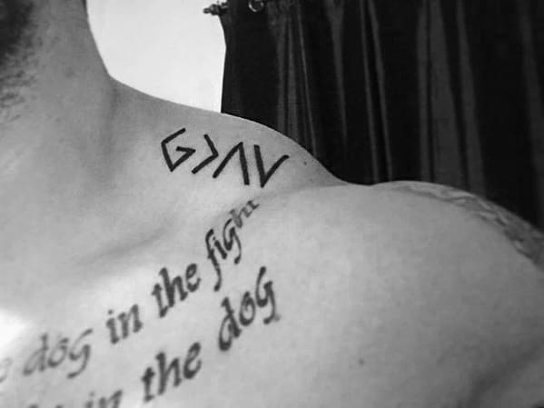 Shoulder tattoo featuring the "God is greater than the highs and lows" symbol in bold minimalist design